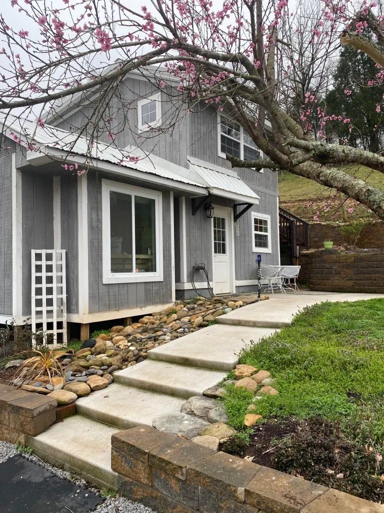 Two-story wooden home with a covered porch, built for the dogs at Sherman’s Shih Tzu Puppies